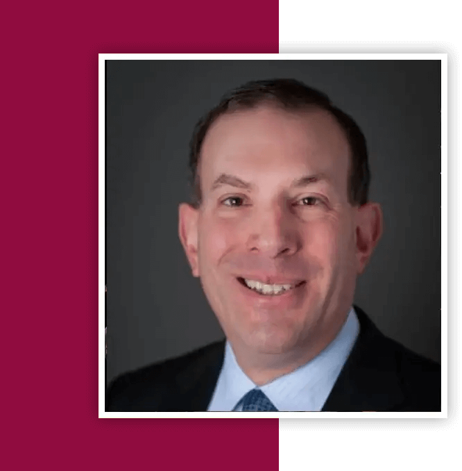 A man in suit and tie smiling for the camera.