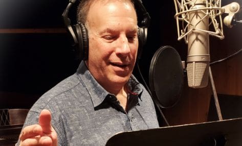 A man wearing headphones and holding his hand out to someone.